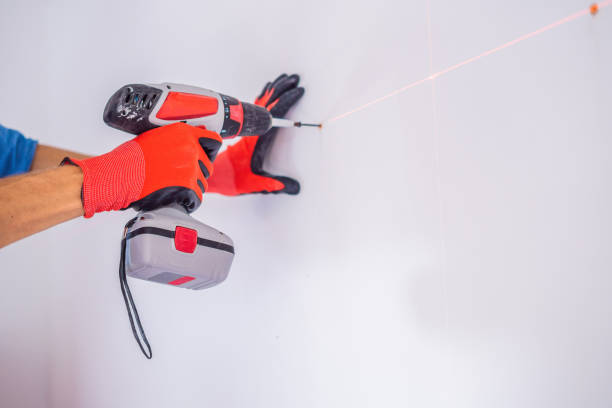 istock Man twists a screw into the wall 1086184608