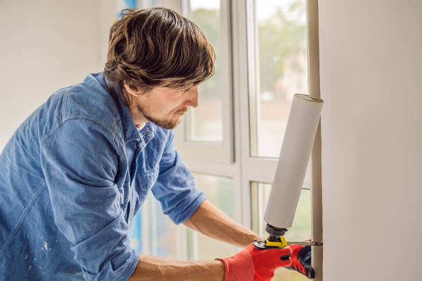 istock Man in a blue shirt does window installation 1086185024