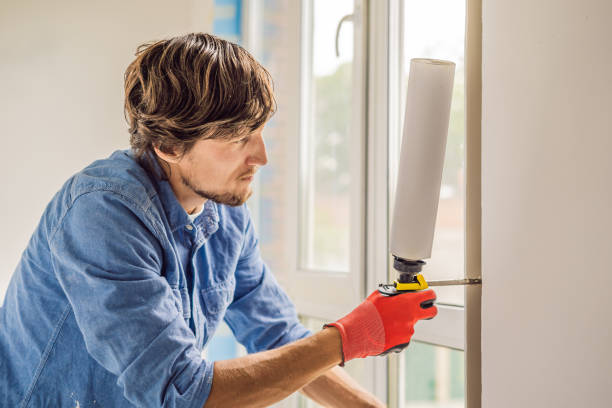 istock Man in a blue shirt does window installation 1086185026