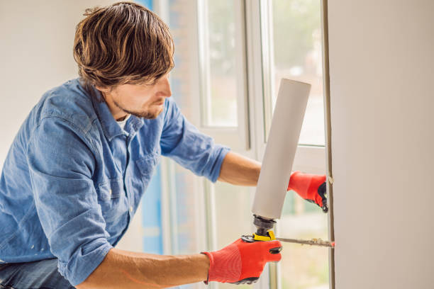 istock Man in a blue shirt does window installation 1086185052