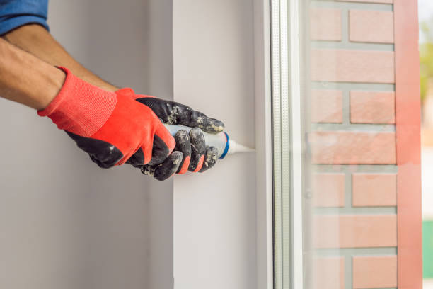 istock Man in a blue shirt does window installation 1086186482