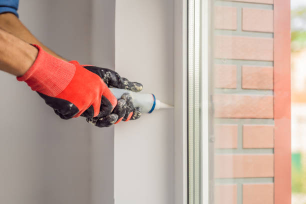 istock Man in a blue shirt does window installation 1086186492