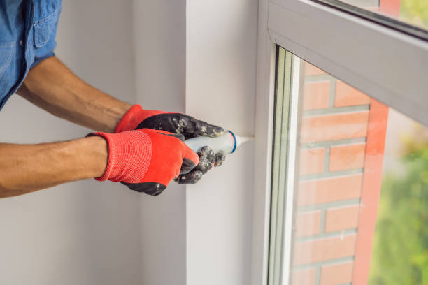 istock Man in a blue shirt does window installation 1086186494