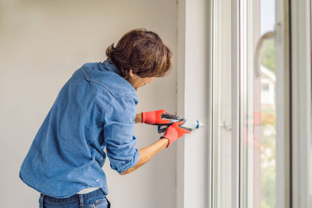 istock Man in a blue shirt does window installation 1086186506