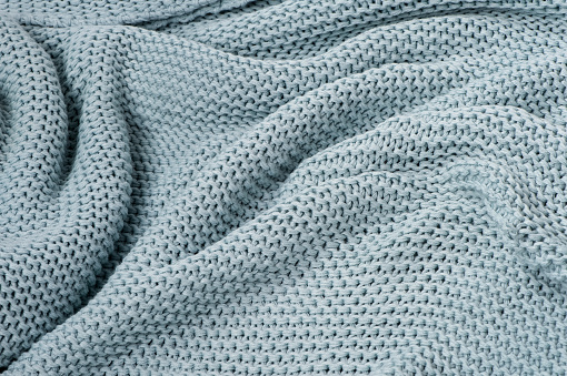 blue knitted plaid close-up wavy textured background