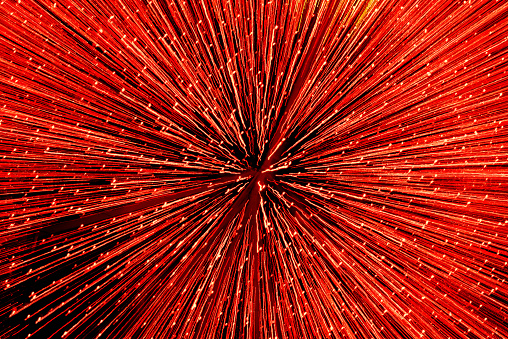 Red blurred background with bright shiny lines of light.