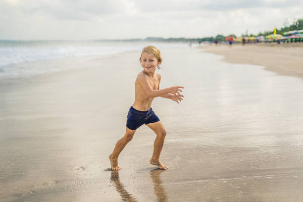 istock boy playing on the beach in the water 1086197520