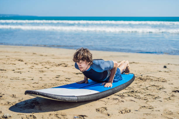 istock Young man surfer training before go to lineup on a sand beach. Learning to surf. Vacation concept. Summer holidays. Tourism, sport 1086199500