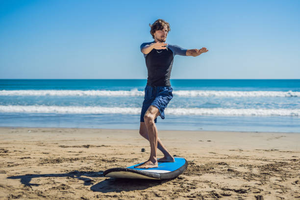 istock Young man surfer training before go to lineup on a sand beach. Learning to surf. Vacation concept. Summer holidays. Tourism, sport 1086199520