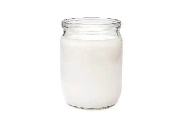 Glass jar with milk on white background.