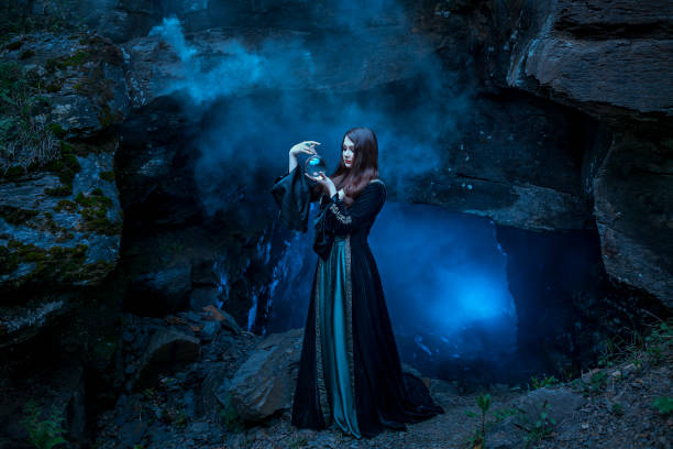 The witch with magic ball in her hands causes a spirits in cave