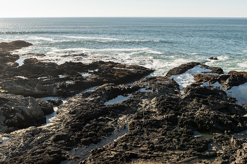 The waves crash on the rocks off the coast at Cape Perpetua Special Interest Area where Thor's well is located, Oregon, USA