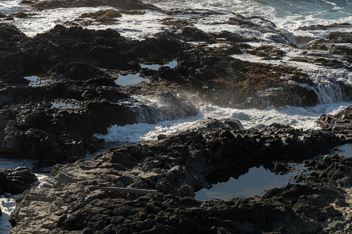 The waves crash on the rocks off the coast at Cape Perpetua Special Interest Area where Thor's well is located, Oregon, USA