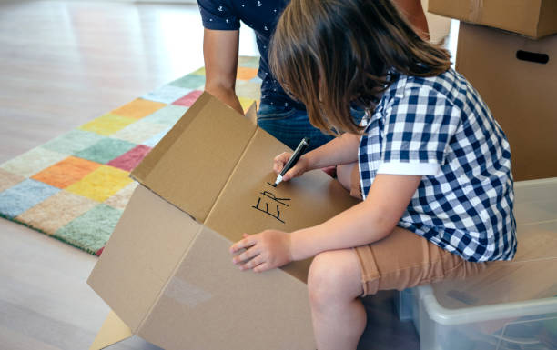 [移動] ボックスを書いている少年 - ラベルを付ける ストックフォトと画像