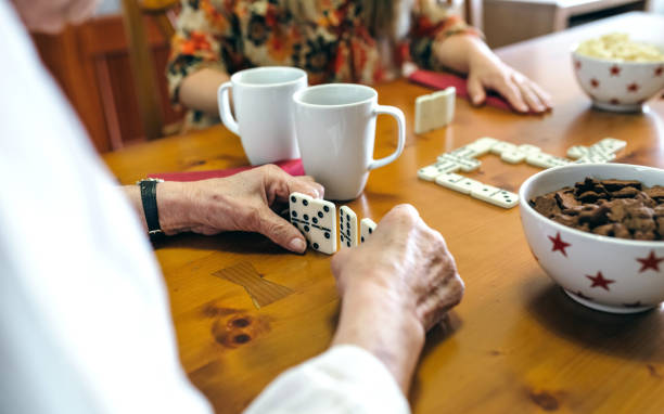 starsza matka i córka grają domino - living room learning healthy lifestyle one person zdjęcia i obrazy z banku zdjęć