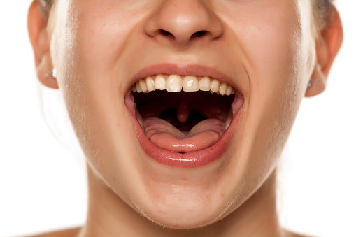 mujer joven con la boca abierta sobre fondo blanco photo