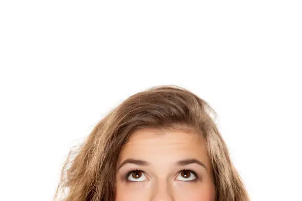 Photo of half portrait of a young girl looking up on white background