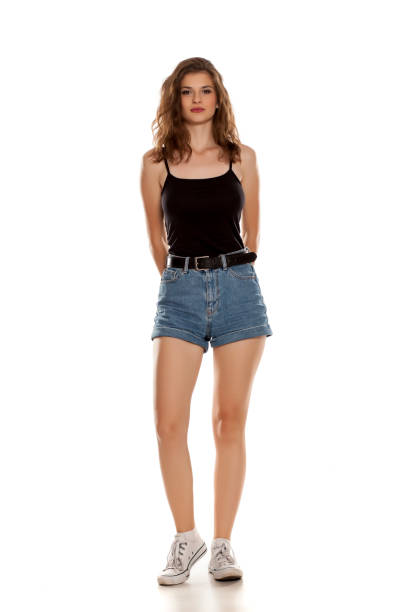 joven bonita a mujer en definitiva jeans sobre fondo blanco - jean shorts fotografías e imágenes de stock