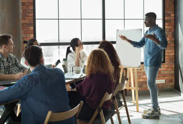 Photo of African-american leader lecturing his employees in office