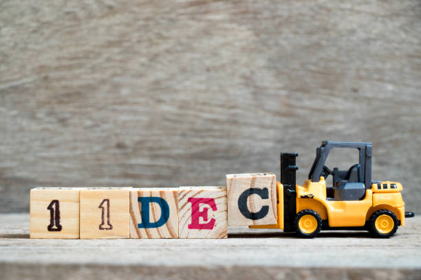 istock Toy forklift hold block c to complete word 11dec on wood background (Concept for calendar date 11 in month December) 1086282430