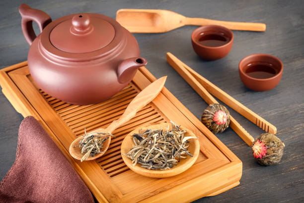 istock green tea and attributes for tea ceremony - a ceramic teapot, cups, a strainer, chopsticks and tweezers are placed on an old wooden table 1086282510