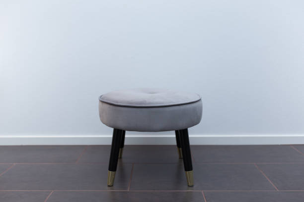 Luxury small chair in front of white wallpaper, on limestone floor stock photo