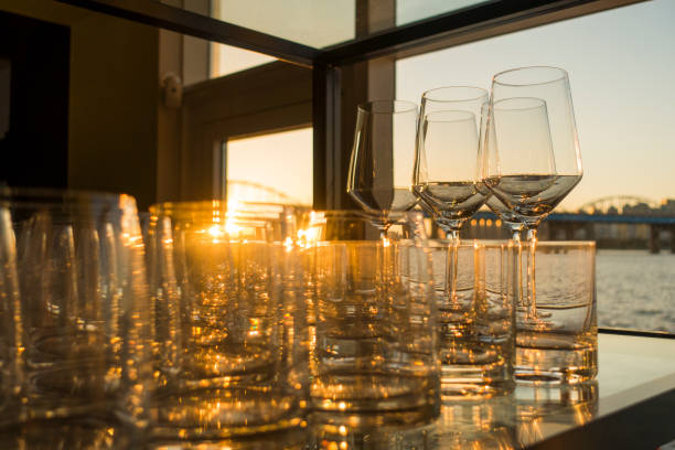 istock Empty glasses of whiskey and wine at sunset on indoor table with river view windows 1086291716