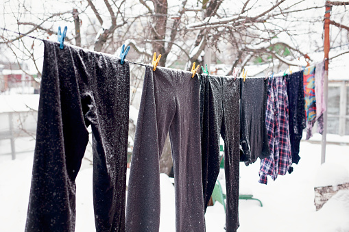Washed laundry hanging outdoors. Winter time.