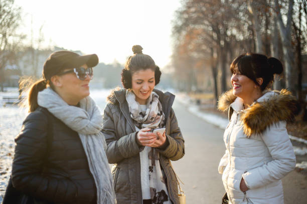 istock Girls walking on snow-covered park and talking 1086305712
