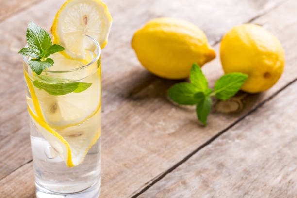 istock Lemon water with fresh lemons and green mint on table 1086311554