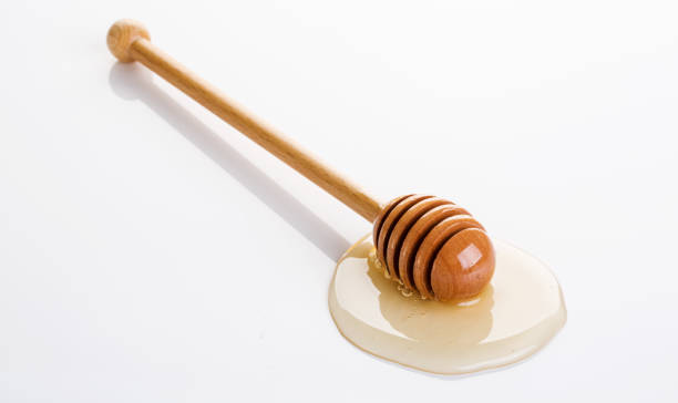 istock Honey and honey dipper on white background 1086313474