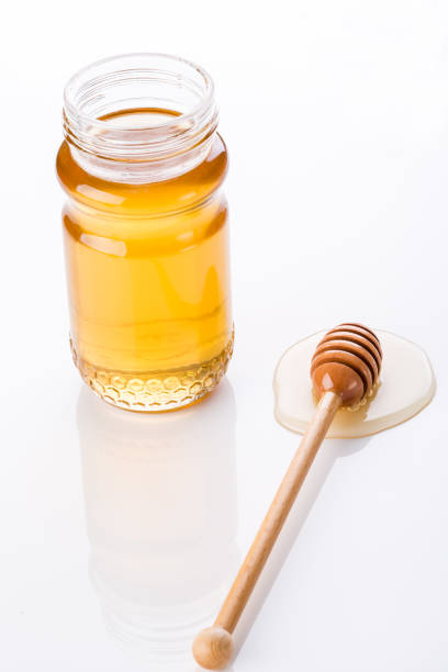 istock Honey and honey dipper on white background 1086313514