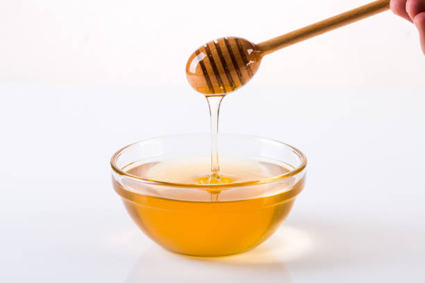 istock Honey with dipper and flowing honey 1086313618