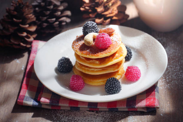istock Pancake topping with berries and nut with background gift and pine cone under christmas tree, holiday party dessert. 1086313646