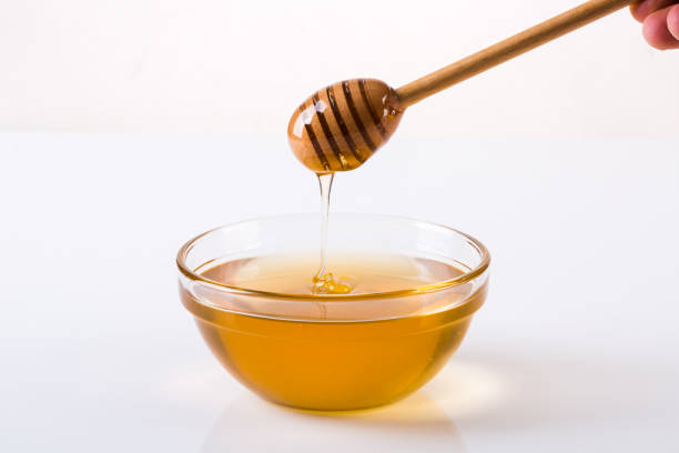istock Honey with dipper and flowing honey 1086313716