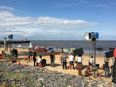 Buenos Aires province, Argentina - December 19, 2018: Film crew on location in beach next to Rio de la Plata shooting advertising for a local company. It is not unusual to encounter this as a lot of adds are shot in the city and its surroundings all the time