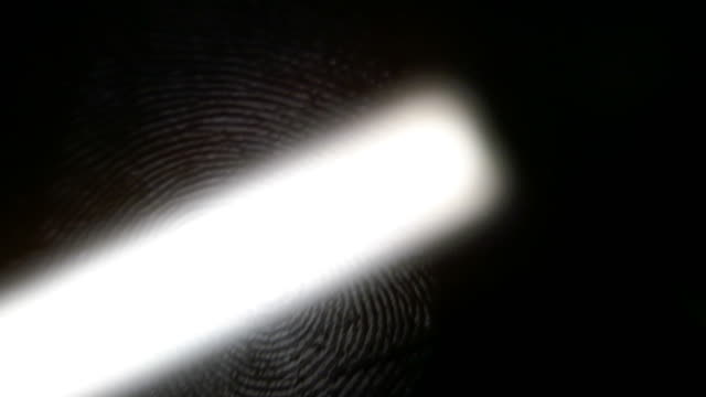 Footage of a fingerprint on a black surface being scanned