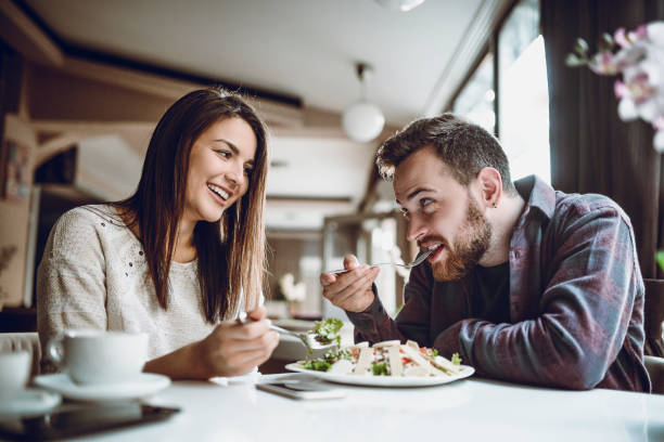 istock Cute Couple Having Romance While Sharing Caesar Salad In Restaurant 1086330844