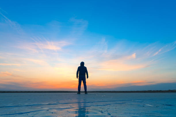A man standing on the ice at sunset