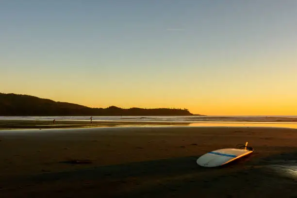 A surfboard is located on a beach on Vancouver Island