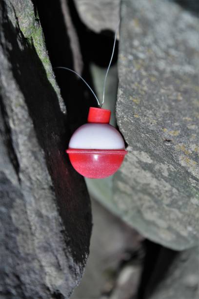 istock Small fishing bobber wedged in between rocks 1086339590