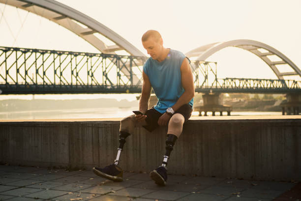 istock Young man with prosthetic leg sitting outside texting 1086339786