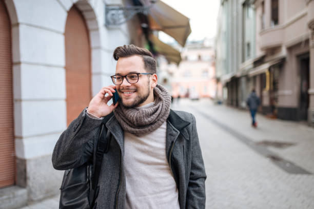 istock Hipster man talking on smart phone in winter town. 1086350298