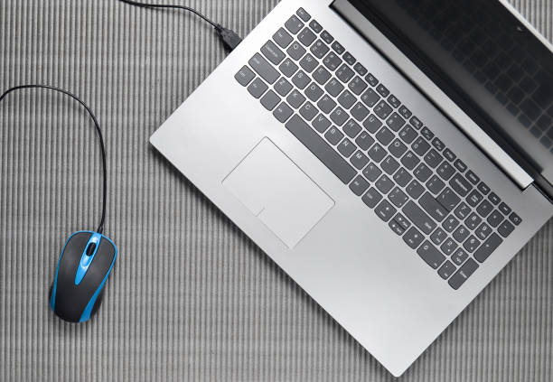 istock Laptop and computer mouse on a gray textured background, top view 1086350422