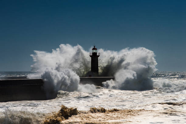 istock Dramatic Lighthouse Seascape and Extreme spray 1086356982