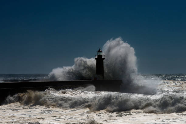 istock Dramatic Lighthouse Seascape and Extreme spray 1086357230