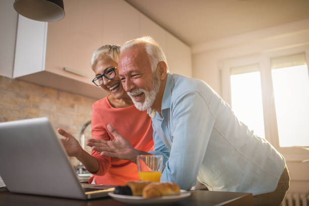 älteres paar eine video-chat-sitzung mit ihrer familie genießen - family domestic life senior adult computer stock-fotos und bilder