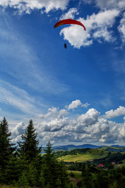istock Paraglider flying over mountains during summer day 1086370362