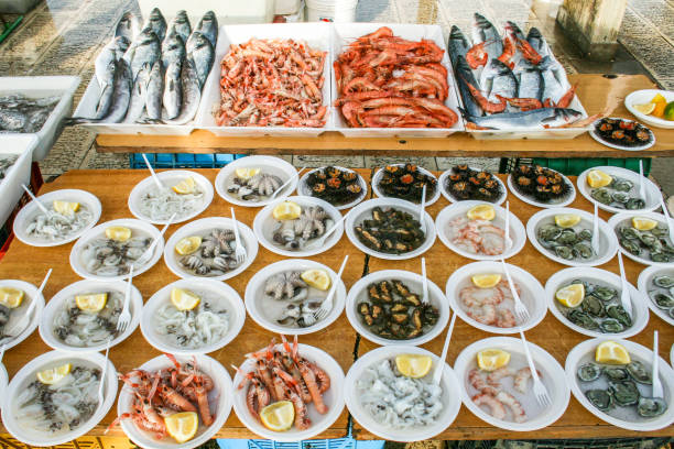 Open air street food fish market on Bari promenade with raw fresh sushi ready to eat: shrimp, oyster, sea urchin, cuttlefish, squid, octopus and salpa, sole and various fish