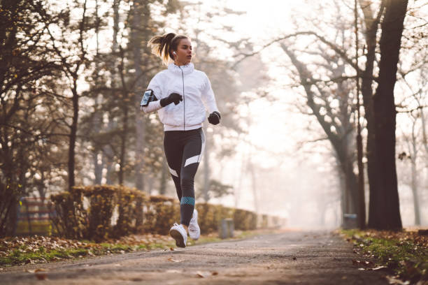 frau im winter morgens joggen - women winter autumn nature stock-fotos und bilder